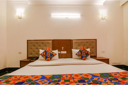 古尔冈FabExpress JDM Residency的一间卧室配有一张带色彩缤纷枕头的大床