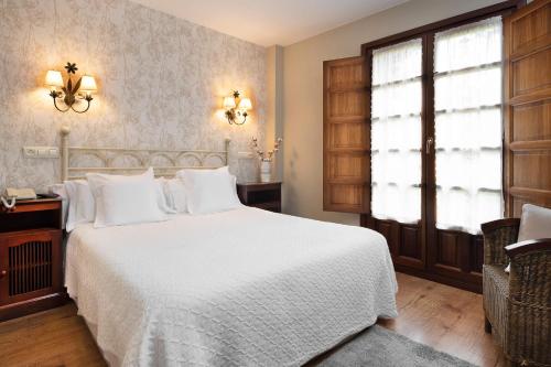 Cefontes卡瑟纳赛冯特乡间酒店的卧室配有白色的床和窗户。