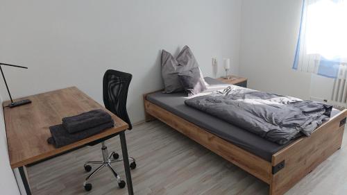 辛茨海姆Apartment Ferienwohnung Vogt的一间卧室配有一张床和一张桌子及椅子