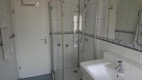 辛茨海姆Apartment Ferienwohnung Vogt的带淋浴、盥洗盆和镜子的浴室