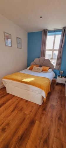 斯旺西Modern and spacious Swansea centre apartment的一间卧室设有一张大床,铺有木地板