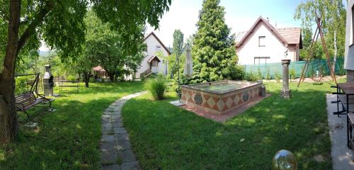 PilisszentivánHill View Holiday House nearby Budapest with AC & Pool的草地上带大浴缸的院子
