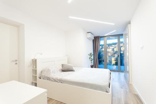 的里雅斯特Casa vacanze Montebello的白色的卧室设有床和窗户