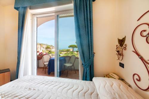 伊斯基亚Hotel Terme Don Pepe的一间卧室配有一张床,享有海景
