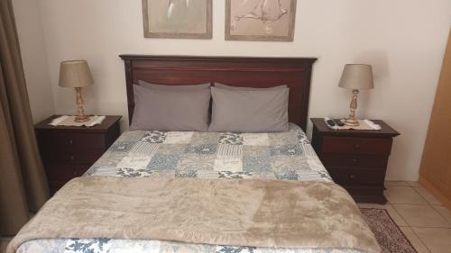 威特班克Lushof Guesthouse的一间卧室配有一张带2个床头柜的大床