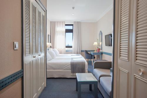 马德里格兰大道埃斯帕酒店的酒店客房设有一间带一张床和一张沙发的卧室