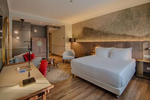 米兰新门NH酒店的一间酒店客房,配有一张白色的床和一张书桌