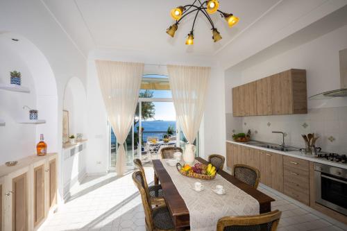 波西塔诺YourHome - Villa Aldo Marino的厨房以及用餐室,配有带水果的桌子。