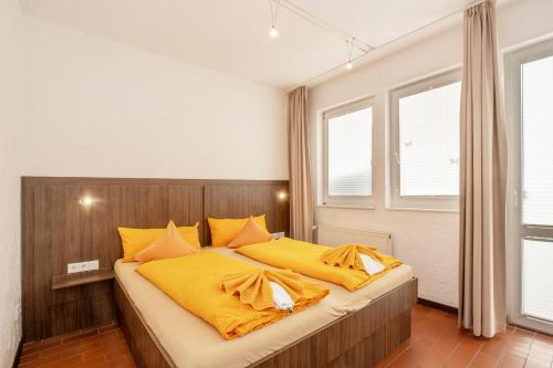 朗格奥Lütje Hus的一间卧室配有一张带黄色床单的大床