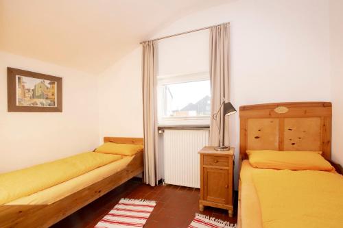 朗格奥Lütje Hus的一间卧室设有两张床和窗户。