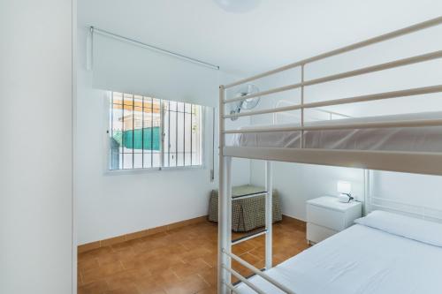 桑卢卡尔-德巴拉梅达Dúplex junto a la playa的一间卧室设有两张双层床和一扇窗户。