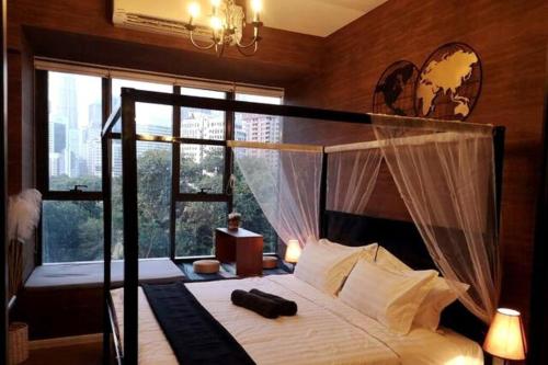 吉隆坡Romantic Log Cabin 2 - Heart of KL, near KLCC/KL Tower的一间卧室设有一张带大窗户的天蓬床