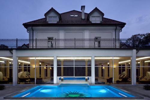 热莱胡夫热莱胡夫宫温泉疗养酒店的一座房子前面设有游泳池