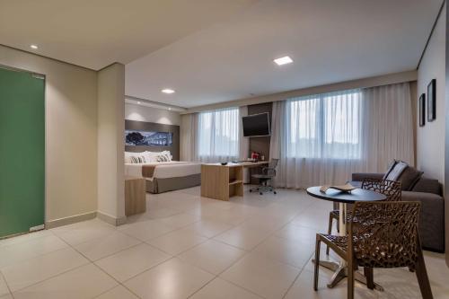 马瑙斯TRYP by Wyndham Manaus的酒店客房带一张床、一张桌子和椅子