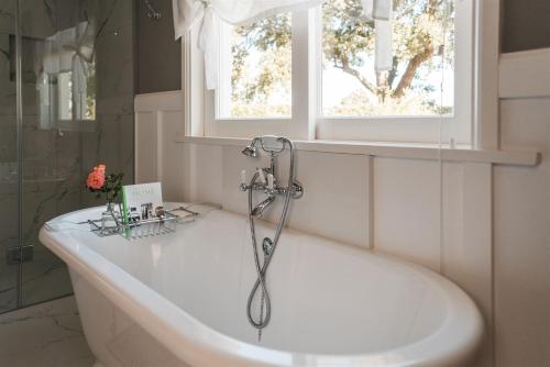 乔治Woodlands Villa的带浴缸的浴室和窗户