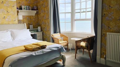 韦茅斯白色悬崖宾馆的卧室配有床、椅子和窗户。
