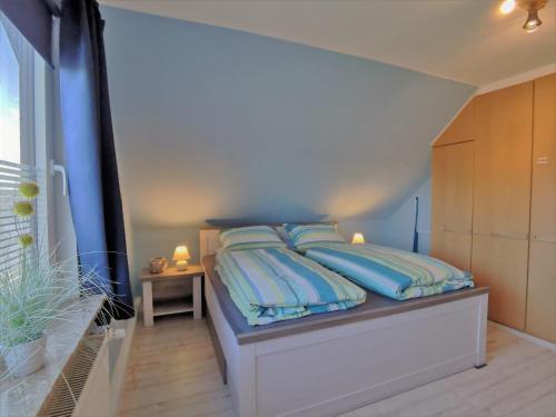 SilberstedtFerienwohnung Thiessen的一间卧室配有一张带蓝色枕头的床。