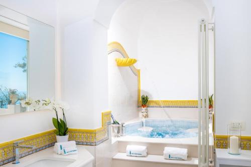 波西塔诺YourHome - Villa Aldo Marino的带浴缸和盥洗盆的浴室