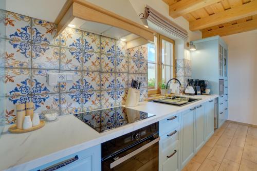 斯祖贝莱克Chalet West - Zuberec的厨房的墙壁上铺有蓝色和白色的瓷砖。
