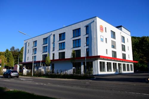 萨尔布吕肯Smart & Stay Aparthotel Saarbrücken Süd - Self-Check-In - Free Parking的街道边的白色建筑