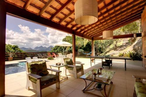 伊泰帕瓦Pousada Alto Itaipava的一个带桌椅的庭院和一个游泳池