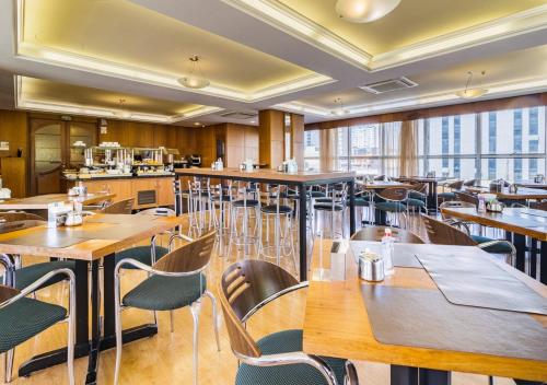 阿雷格里港Ritter Hotéis的餐厅设有木桌、椅子和窗户。