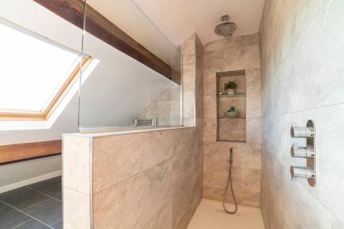 伯恩利Oak Tree Cottage - Pendle - Forest of Bowland的带淋浴的浴室和玻璃墙