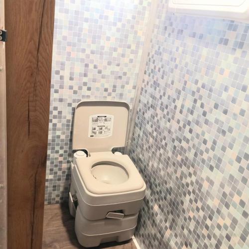Kefar H̱ananyaלנפוש על גלגלים的瓷砖墙内带卫生间的浴室