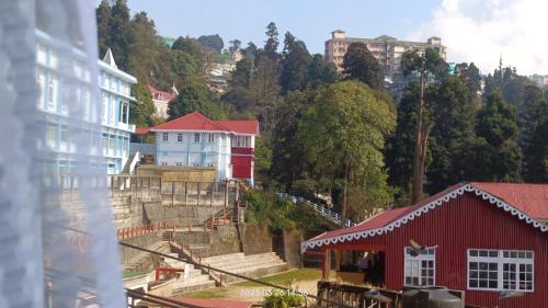 大吉岭Darjeeling Homestay Nyano Ghar的一座山丘上一群建筑,有一座红色的建筑