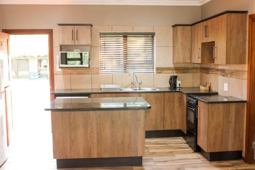 LephalaleRip van Winkel Guest House的厨房配有木制橱柜和黑色台面
