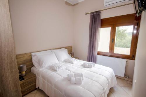 LímniHorio House的卧室配有白色的床和窗户。