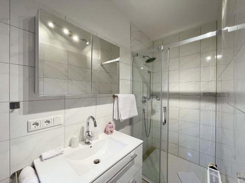 特希尔Marions Apartments Greetsiel的白色的浴室设有水槽和淋浴。