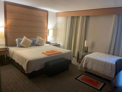 圣保罗Ibirapuera hotel 5 estrelas 2 suites的酒店客房设有两张床和大窗户。