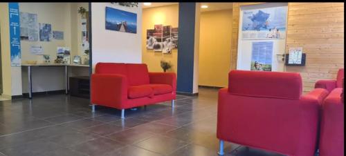 拉菲克拉Le Nivelet Les balcons d'Aix的一间设有红色椅子和墙上海报的等候室