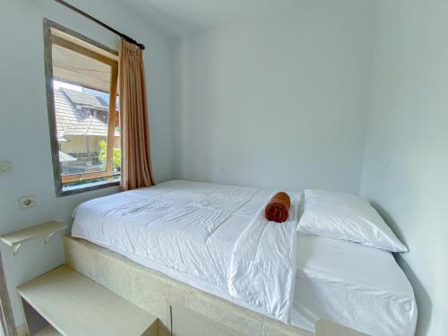乌鲁瓦图霍姆比恩瑟旅舍的卧室配有白色的床和窗户