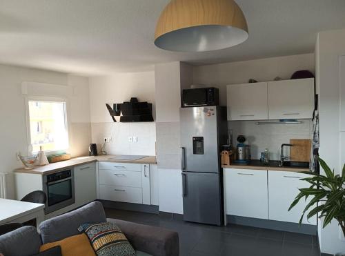 图卢兹Appartement T2 très lumineux + PKG的厨房配有白色橱柜和不锈钢冰箱