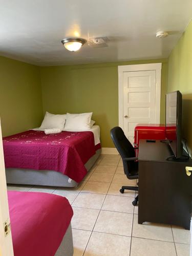 洛杉矶Spacious Private Los Angeles Bedroom with AC & WIFI & Private Fridge near USC the Coliseum Exposition Park BMO Stadium University of Southern California的一间卧室配有一张床和一张带电脑的书桌