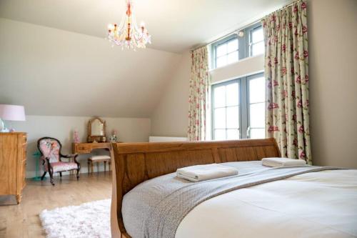 恩尼斯基林Escape Ordinary at Lough Erne Golf Village No.52的一间卧室配有一张床,上面有两条毛巾
