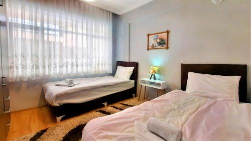 安塔利亚Fully Furnished Stylish Apartment in Antalya的一间卧室设有两张床和窗户。