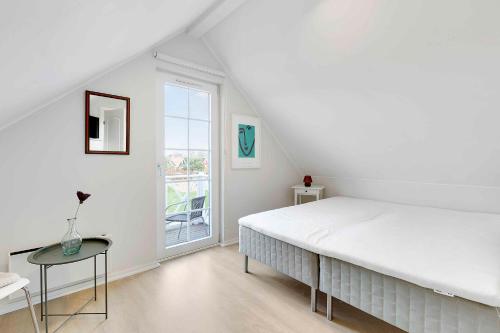 布罗Charming Architect-designed Terraced House With Sea View的白色的卧室设有一张大床和一个窗户