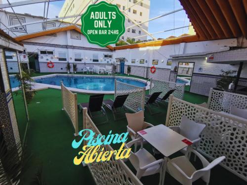 塞维利亚Hostal Avenida Andalucia的游轮甲板上的游泳池,配有桌椅
