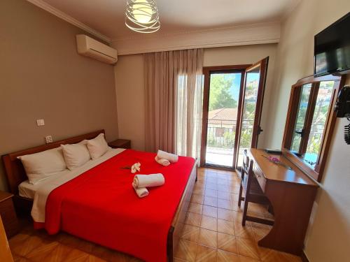 伊古迈尼察Zigos Apartments的一间卧室配有红色的床和毛巾