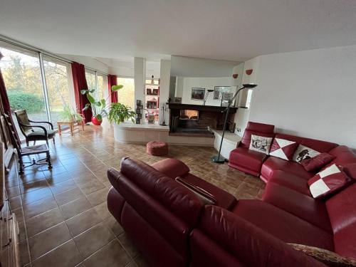 勒芒Gazonfier的一间带红色沙发的客厅和一间厨房