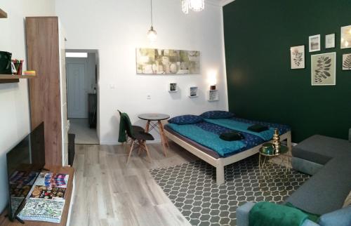 塞格德Hanna apartman的一间卧室配有一张床、一张桌子和一张沙发