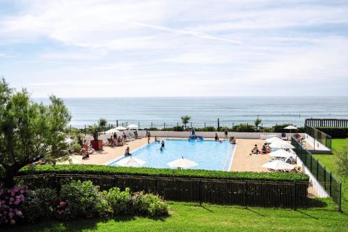 安格雷Belambra Clubs Anglet - La Chambre d'Amour的享有游泳池的景色,背景是大海