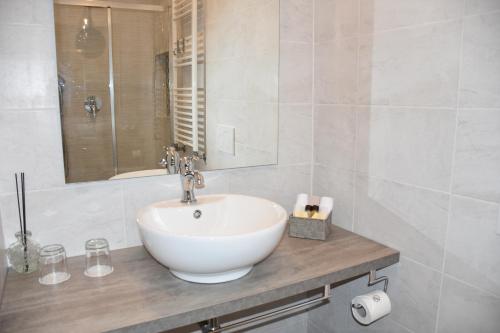 帕维亚R & A Minerva Suites的白色的浴室设有水槽和镜子