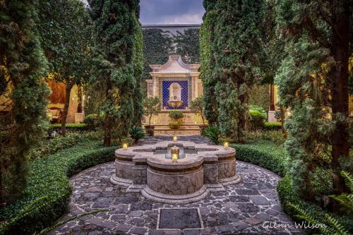 危地马拉安地瓜圣拉斐尔酒店 的一座花园,房子前面有一个喷泉