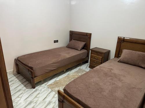 阿尤恩appartement meublé à Laâyoune的一间卧室设有两张床和两个床头柜