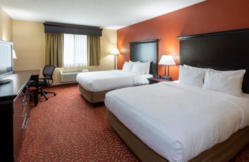 CambridgeGrandStay Hotel & Suites的酒店客房设有两张床和一台平面电视。
