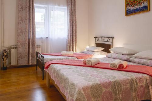 奈维斯Apartmani Justić的一间卧室配有三张红色和白色床单